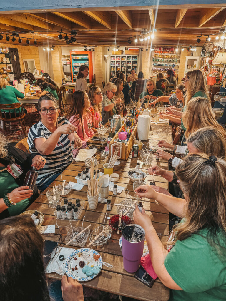 Large group of Women pouring candles together at at granny camp workshop, smiling and having fun.