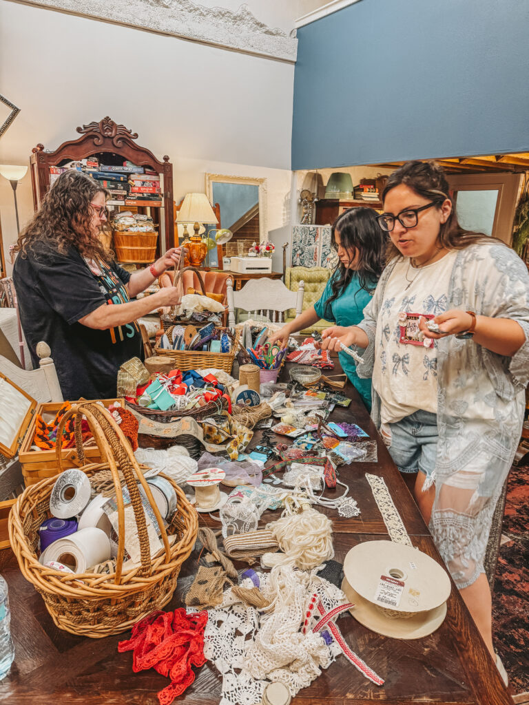 Women smiling and crafting together at the Petals and Patina shabby chic DIY event hosted at Granny Camp.