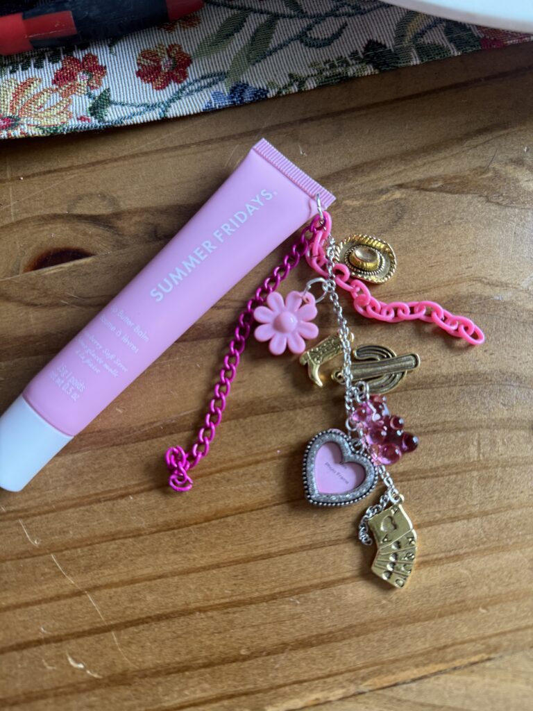 Step-by-step tutorial for DIY lip gloss charms featuring purple Summer Fridays balm, jewelry pliers, pink heart locket, and gold western charms on a wood table.