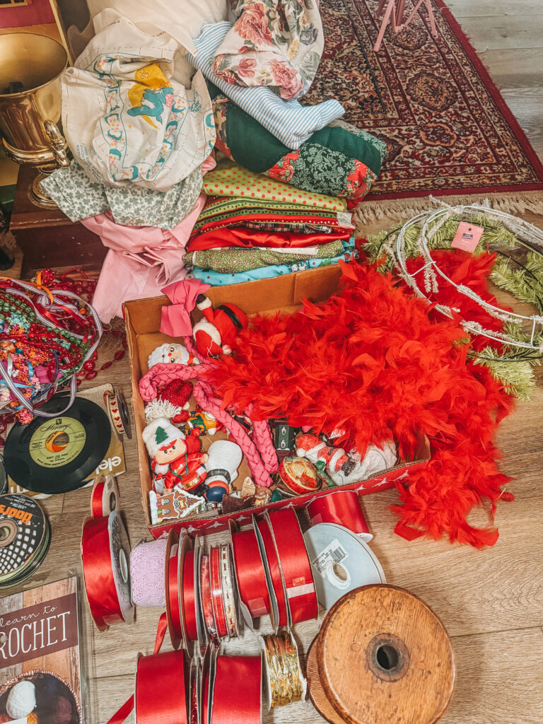 Close-up of stacked fabrics, patterned textiles, and thrifted craft items with rich colors and textures from a Houston Goodwill bins haul.