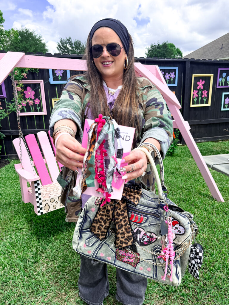 Ashton Sedita holding a handmade 90s-themed junk bookmark in front of a colorful picture frame DIY picket fence.