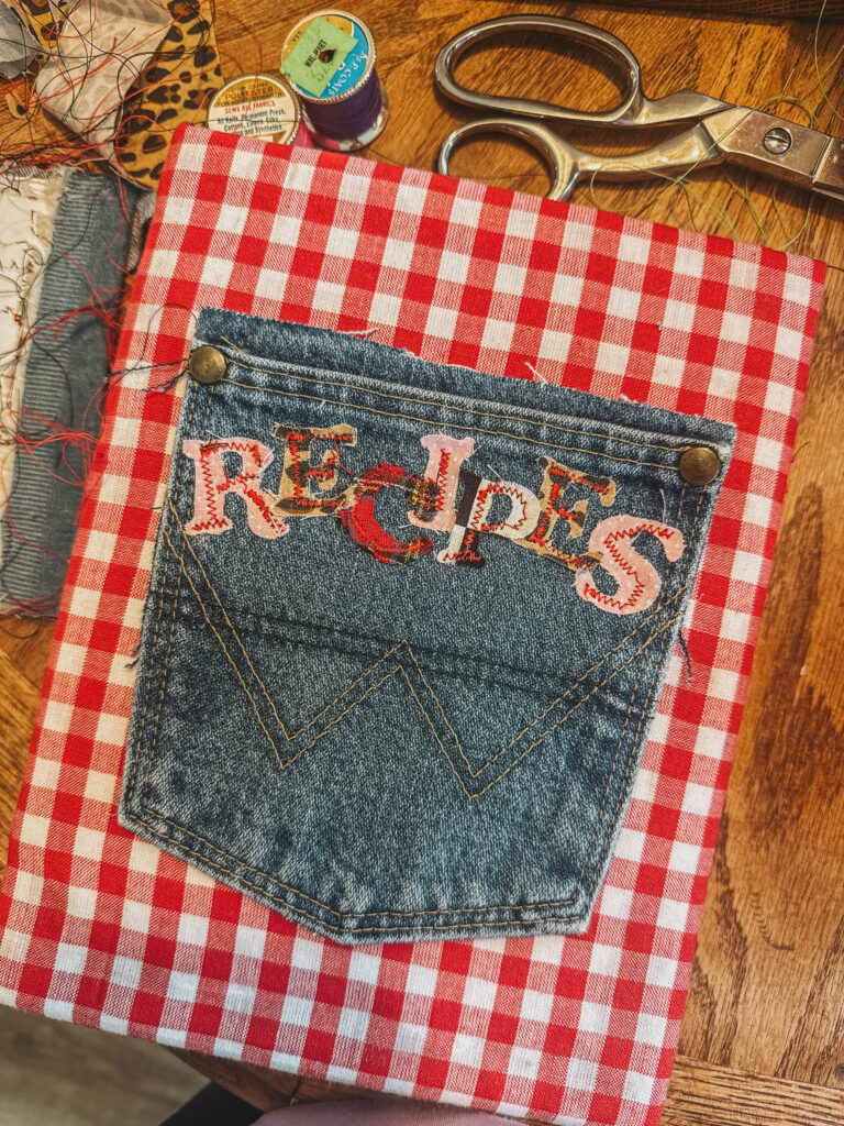  the completed denim pocket with fabric letters spelling 'RECIPES' resting on a gingham background.