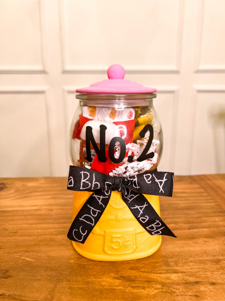 small decorative yellow and pink gum ball machine.