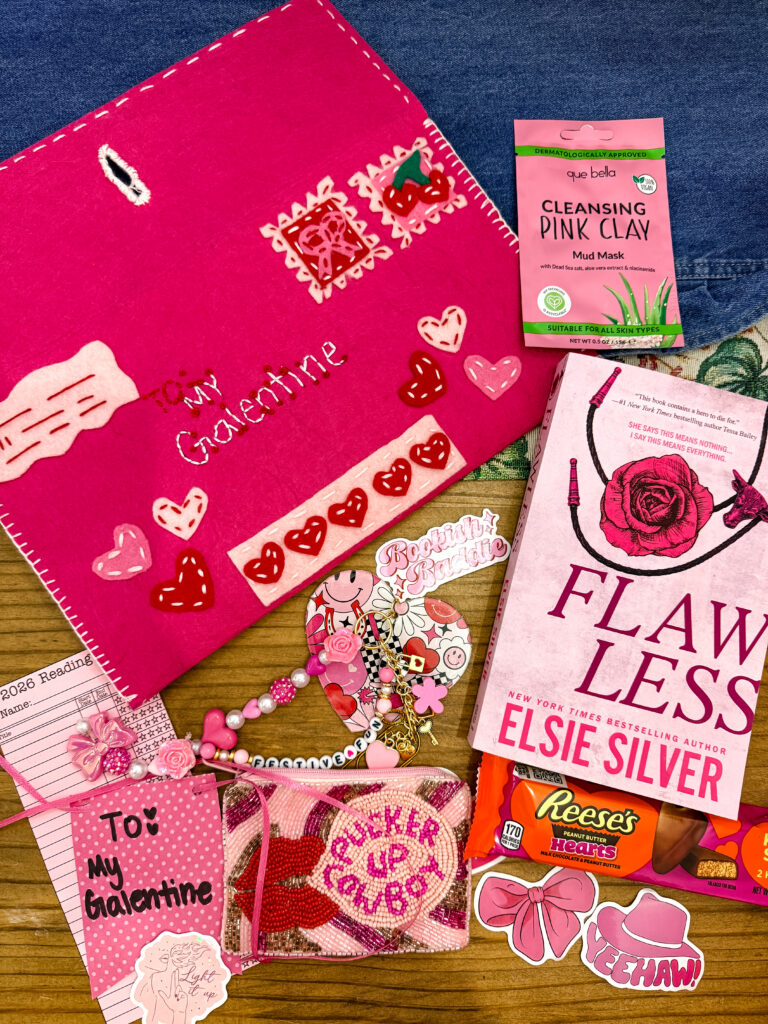 A western-themed Galentine's Day book bundle featuring a red "To My Galentine" felt envelope, the romance novel "Flawless" by Elsie Silver, a face mask, Reese's hearts, and a "Pucker Up Cowboy" beaded coin purse.